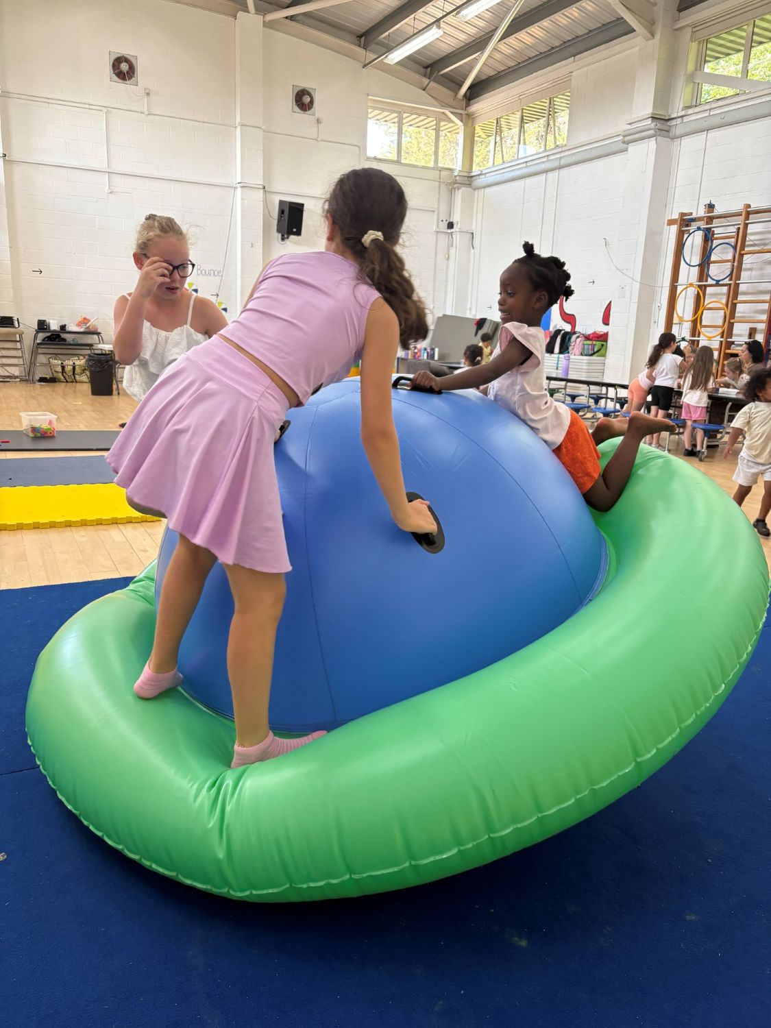 Children playing together on a large inflatable in the hall