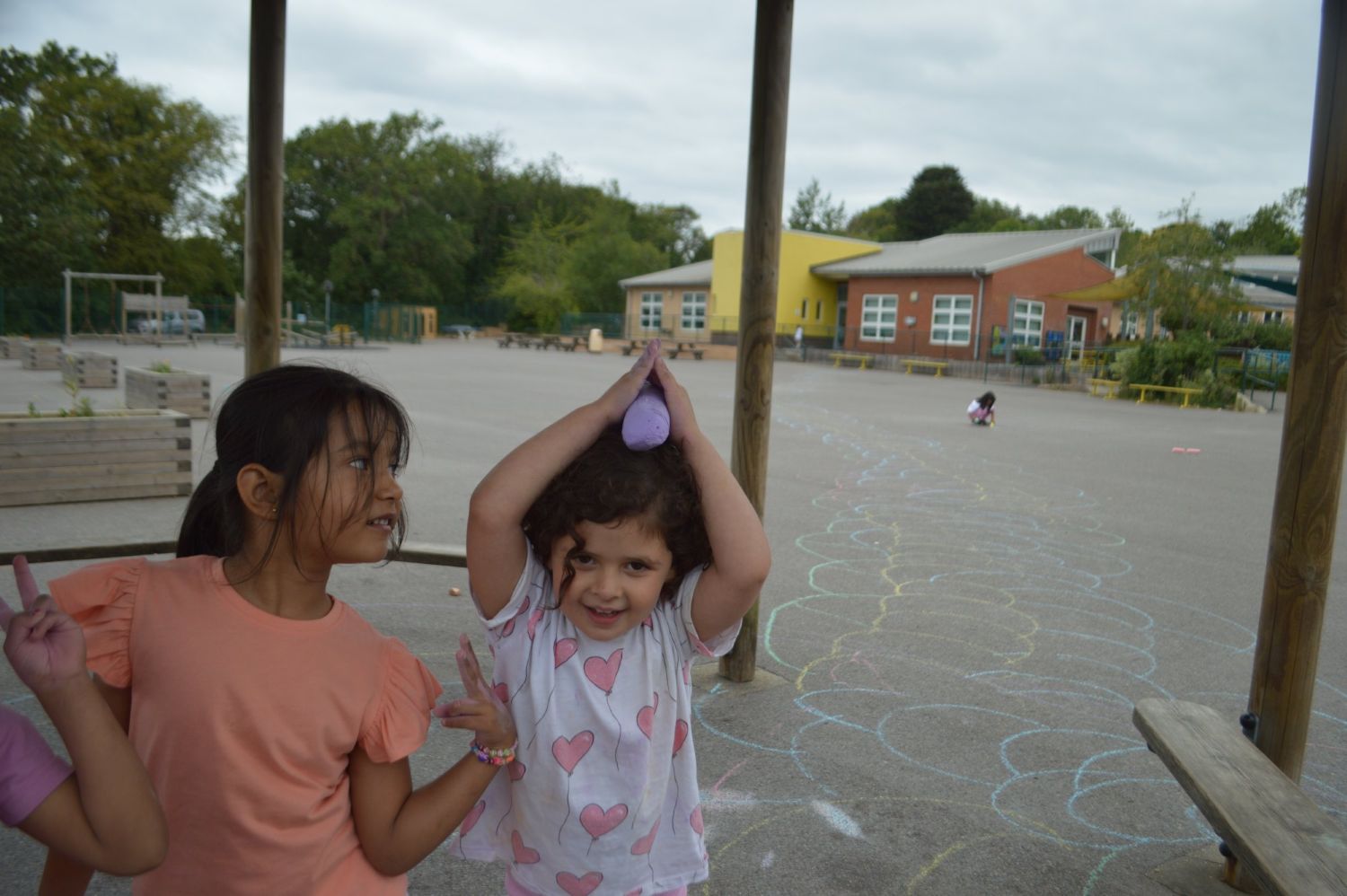 Children drawing with chalk in the school playground at camp