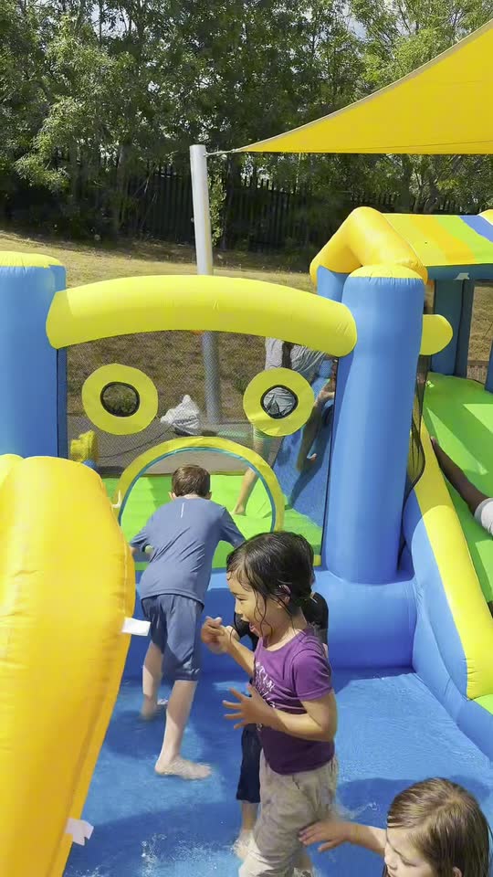 Children playing in the inflatable water park at Essence Sports summer camp